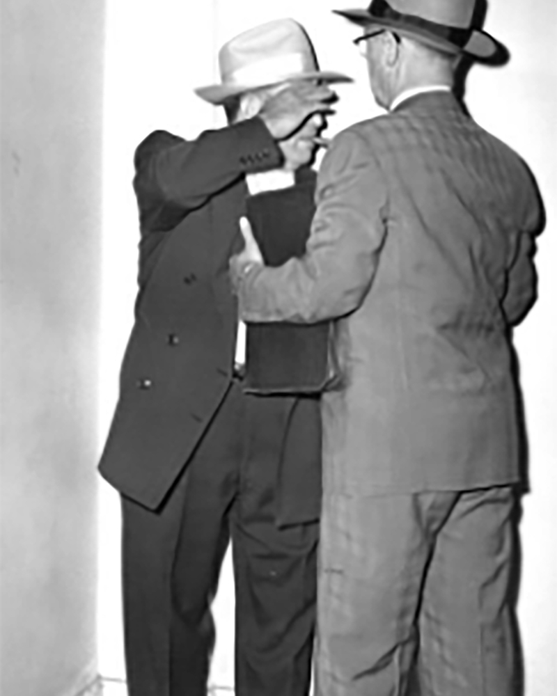 Clyde Smaldone hides his face from a photographer in 1952.