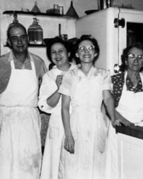 A photo of the staff at Gaetanos’ kitchen with Smaldone family patrich, Mamie Smaldone (far right), cooking. Taken in 1956.